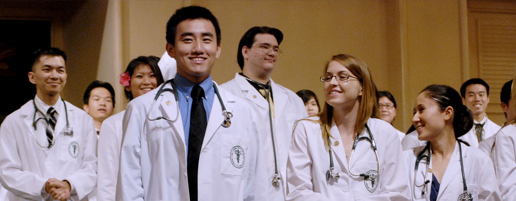 medical student graduates in white coats